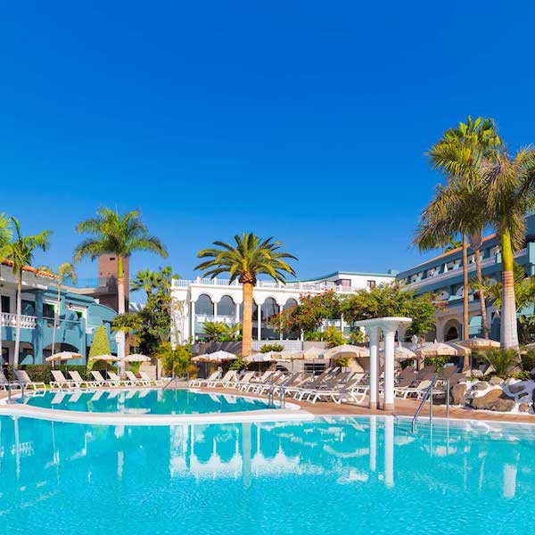Pool surrounded by palms at Colon Guanahani Hotel